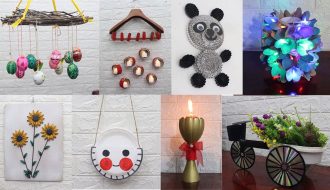 Renkli cam şişeler, karton kutular ve kumaş parçaları gibi atık malzemelerle hazırlanmış el yapımı dekoratif objelerin ahşap bir masa üzerinde sergilendiği görüntü.