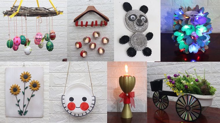 Renkli cam şişeler, karton kutular ve kumaş parçaları gibi atık malzemelerle hazırlanmış el yapımı dekoratif objelerin ahşap bir masa üzerinde sergilendiği görüntü.