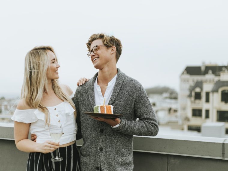Bir çift birlikte masa başında not alıyor ve plan yapıyor; birbirlerine bakarak gülümsüyor ve ortak hedefler üzerinde konuşuyorlar.