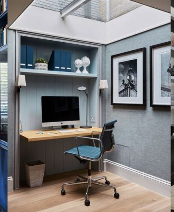 Aydınlık ve düzenli bir ev ofis masası, bilgisayar, not defteri ve düzenleyici kutularla çalışma alanı.