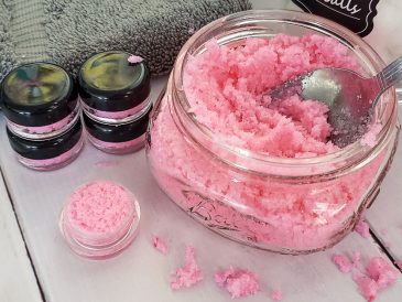 Evde hazırlanmış dudak peelingi kavanoz içinde, yanında doğal malzemeler ve fırça ile birlikte.