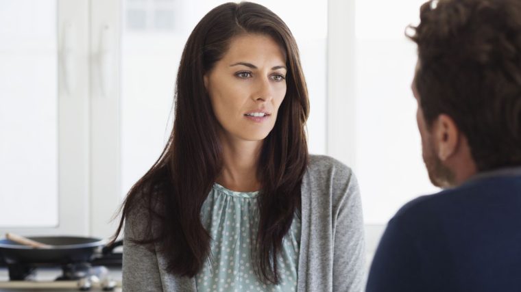 Karşısındaki kişiye konuşurken tereddütle bakan, dudakları arasından “hayır” demeye çalışan bir kişinin düşünceli şekilde ellerini birleştirdiği anın görüldüğü, arka planı flu bir iç mekân sahnesi.